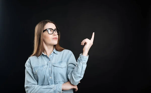 Mujer joven mientras levanta su dedo índice — Foto de Stock