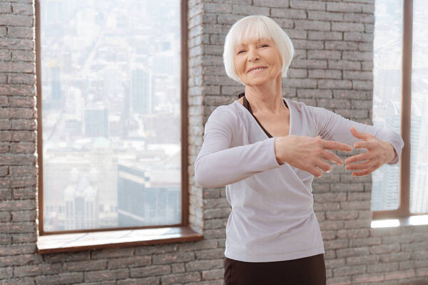 Optimistic aging woman tangoing at the dance lesson