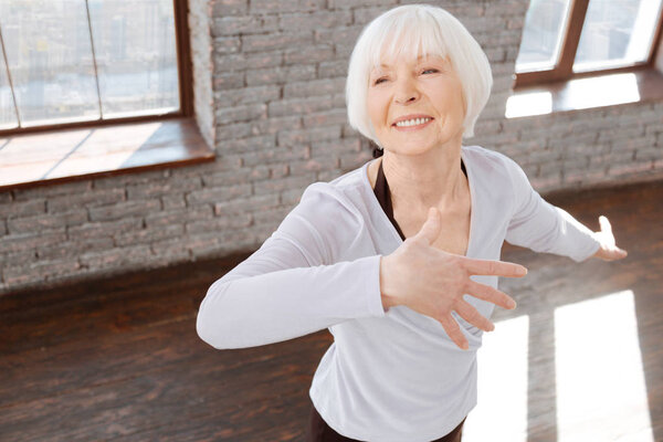 Charming elderly woman dancing at the ballroom