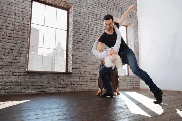 Delighted dance instructor tangoing with senior woman at the ballroom — Stock Photo, Image