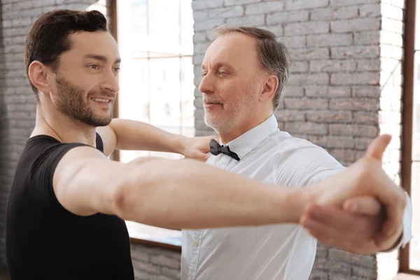 Encantado instructor de baile enseñando a un anciano en el salón de baile — Foto de Stock