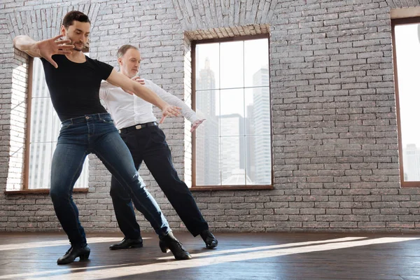 Charismatic dance couch teaching aging man tango at the ballroom — Stock Photo, Image