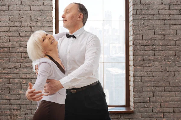 Живая пожилая пара танцует танго в бальном зале — стоковое фото