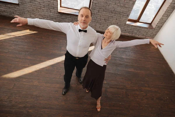 Positive aged dance couple waltzing in the dance studio — Stock Photo, Image