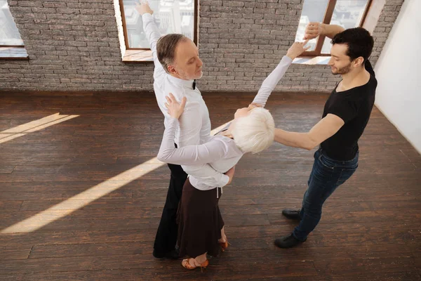 Helpful dance couch teaching retired people in the ballroom