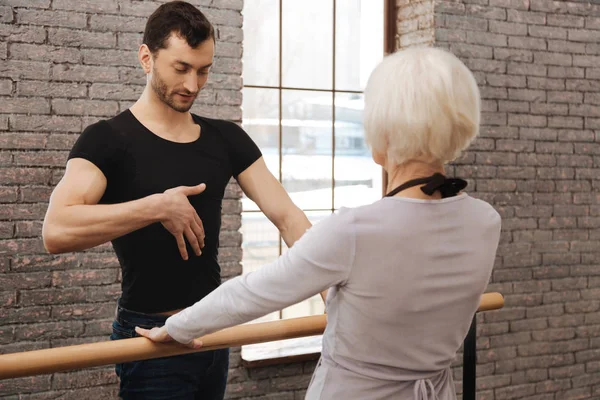 Confident dance teacher instructing elderly woman in the dance studio — Stock Photo, Image