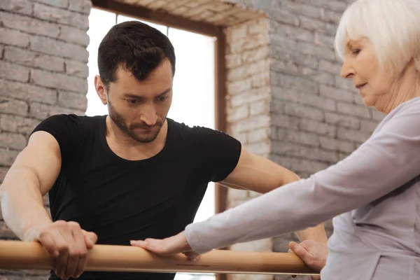 Involved serious dancer teaching pensioner in the dance studio — Stock Photo, Image