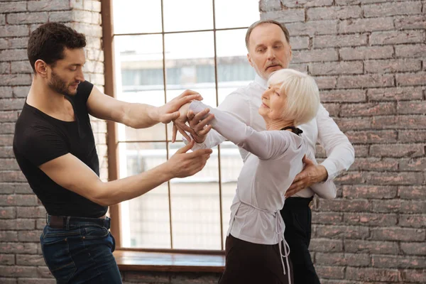 Talentoso instrutor de dança ensinando casal envelhecido no salão de baile — Fotografia de Stock