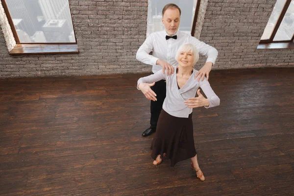 Вовлечённая пожилая пара, выступающая в танцевальной студии — стоковое фото