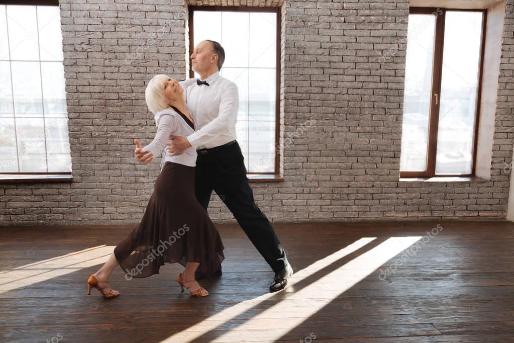 Harmonious senior dance couple dancing tango at the ballroom — Stock Photo © yacobchuk1 147966659