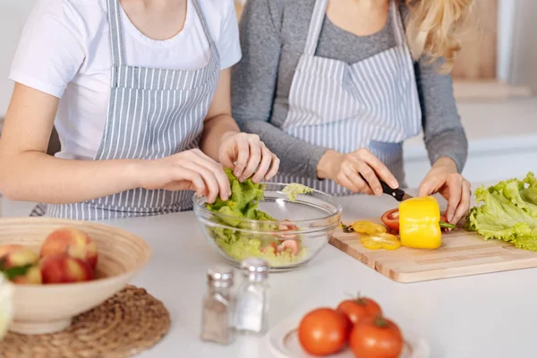 Agradable involucrado madre e hija cocinar ensalada de verduras — Foto de Stock