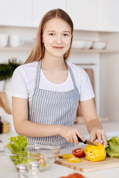 Веселая девочка-подросток готовит здоровый ужин на кухне — стоковое фото