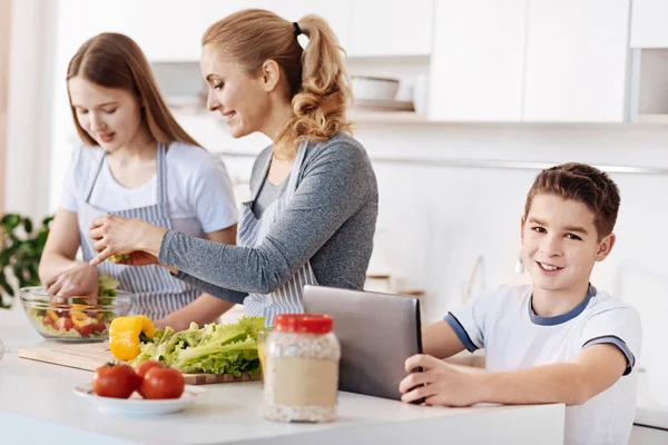 Rapaz positivo usando tablet na cozinha — Fotografia de Stock