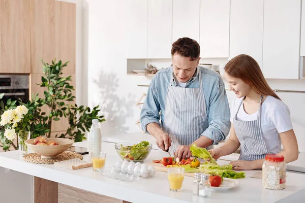 POsitive father and his daughter cooking together