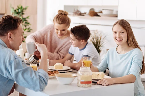 Весела мила дівчина снідає зі своєю дружньою сім'єю — стокове фото