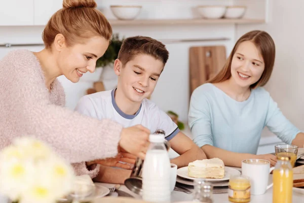 Позитивная мать завтракает со своими детьми — стоковое фото