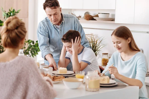 Zorgzame vader dwingt zijn zoon om te ontbijten — Stockfoto