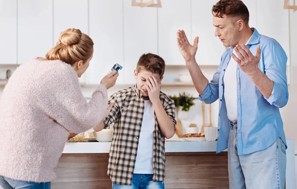 Sorgsame Eltern bestrafen ihren Sohn in der Küche — Stockfoto