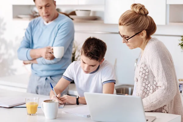 Ijverige jongen huiswerk met zijn ouders — Stockfoto