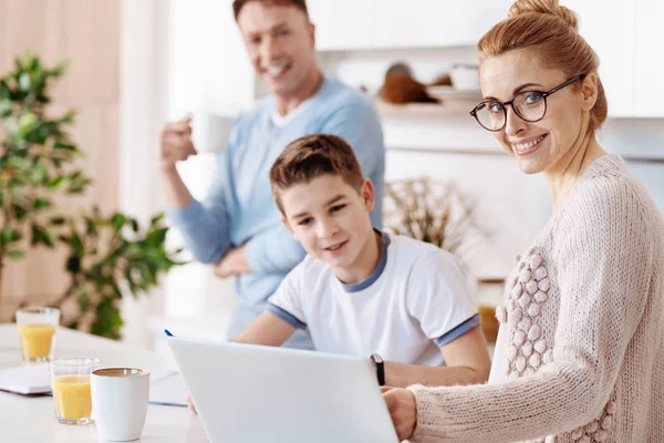 Cheerful mother helping her son with homework — Stock Photo, Image