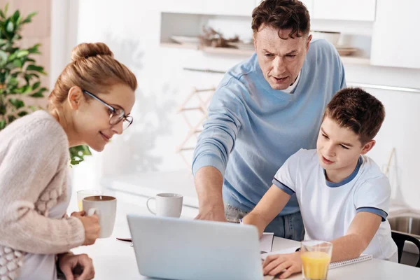 Заботливая семейная пара помогает сыну с домашним заданием — стоковое фото