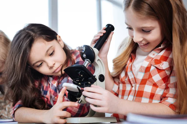 Chica inteligente de apoyo ayudando a su amigo con el experimento —  Fotos de Stock