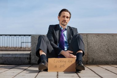 Kaldırımda oturan endişeli ofis çalışanı