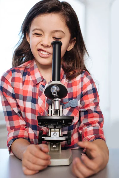 Criança adorável emocional olhando através de um microscópio — Fotografia de Stock