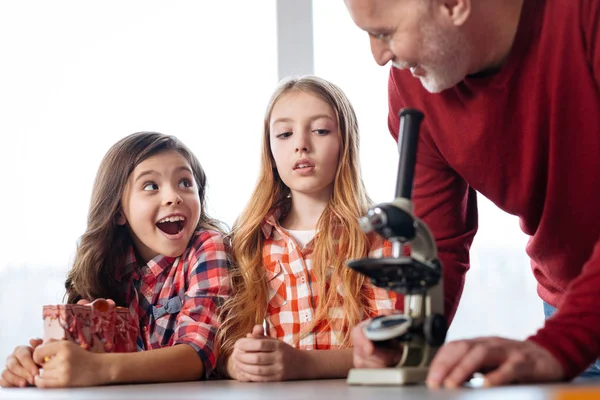 Emocjonalne ciekawskie dzieciaki fascynuje się przy użyciu mikroskopu — Zdjęcie stockowe