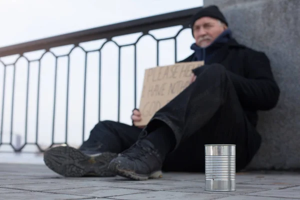 Zamknij się obraz cyny stojący w pobliżu bezdomnego — Zdjęcie stockowe