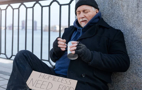 Attentive male person keeping tin in left hand — Stock Photo, Image