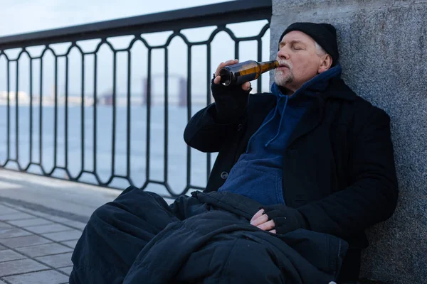 Ленивый седой мужчина пьет пиво — стоковое фото