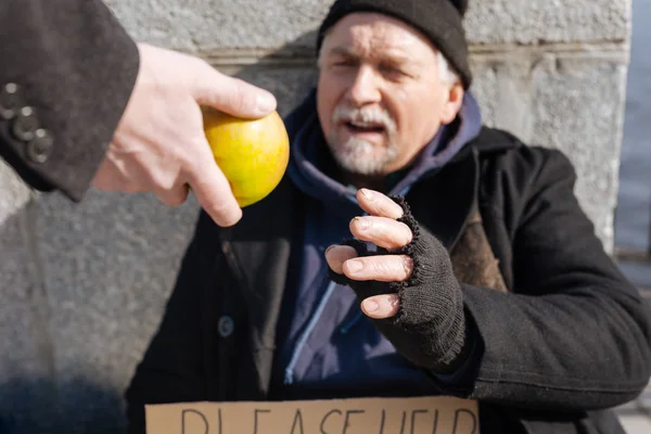 Stackars hemlös man tar apple — Stockfoto