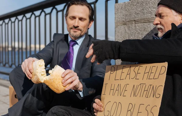 Positiva morena encantada compartiendo pan en dos piezas —  Fotos de Stock