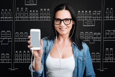 Onun smartphone tutan neşeli pozitif kadın