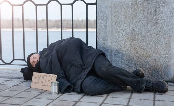 Неопрятный мужчина, спящий на улице — стоковое фото