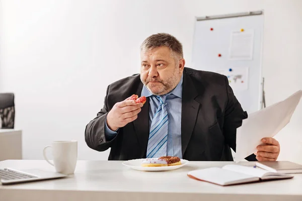 Gewezen werknemer die vulling zelf met gebakken zoetigheden — Stockfoto