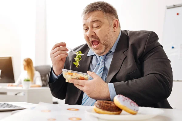 Comical chubby guy not sticking to his diet — Stock Photo, Image