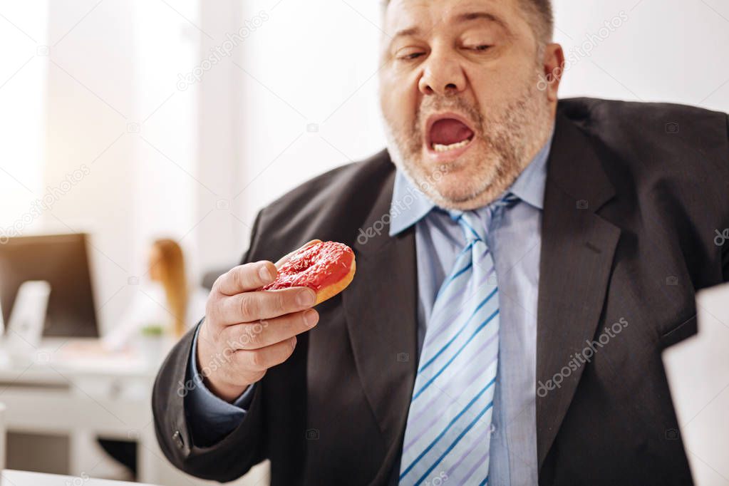 Stressed out busy employee enjoying a doughnut