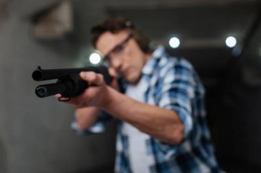 Selective focus of a rifle being in use clipart