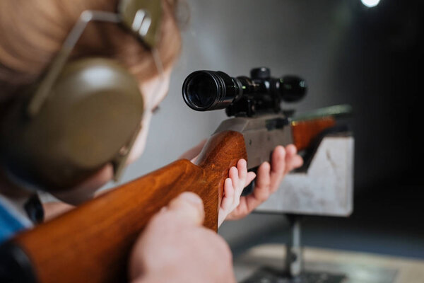 Confident pretty girl shooting at the target