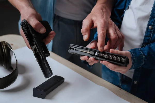 Nice pleasant man pointing at the handgun spring — Stock Photo, Image