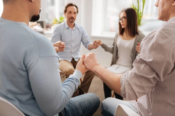 Primer plano de las manos masculinas mientras está sentado en círculo — Foto de Stock