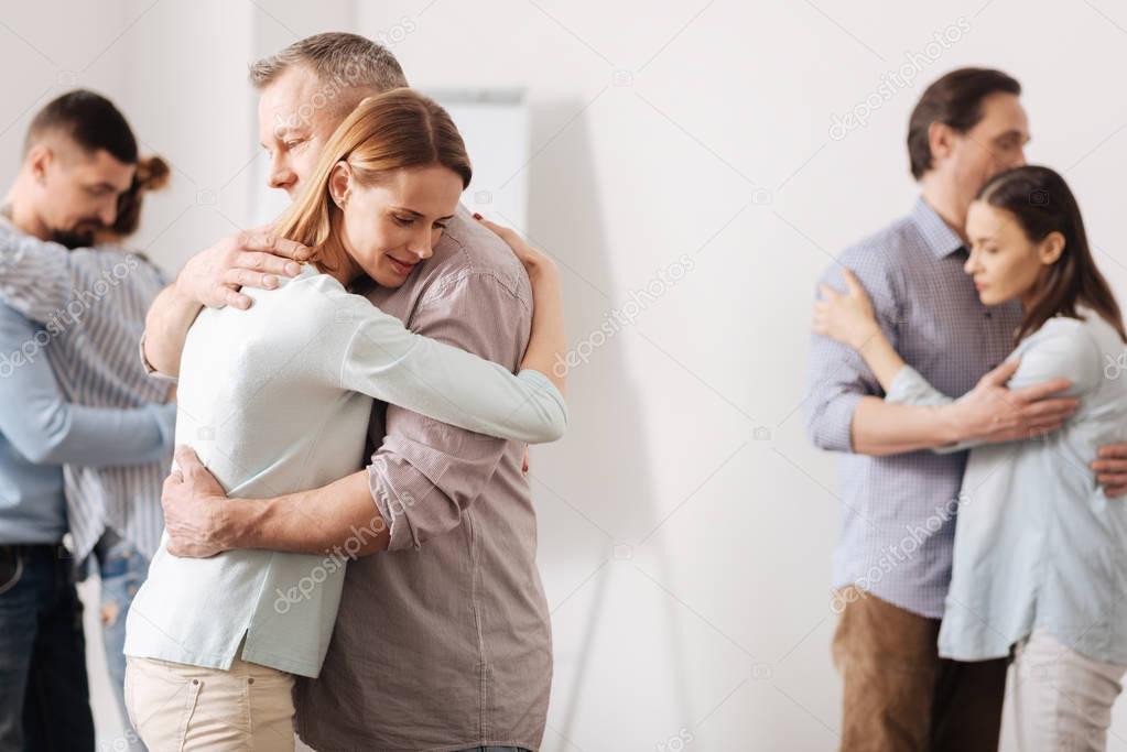 Three pairs of coworkers embracing each other