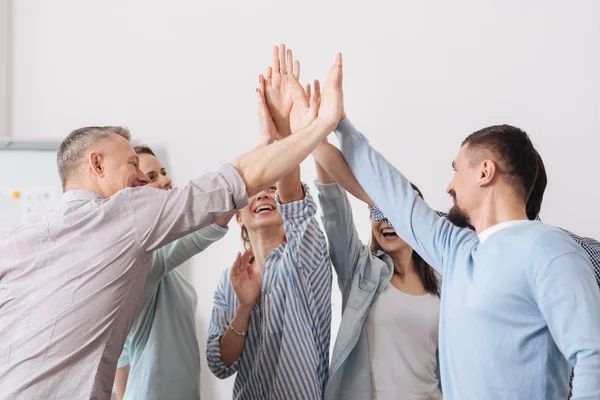 Smiling people rising hands upwards — Stock Photo, Image