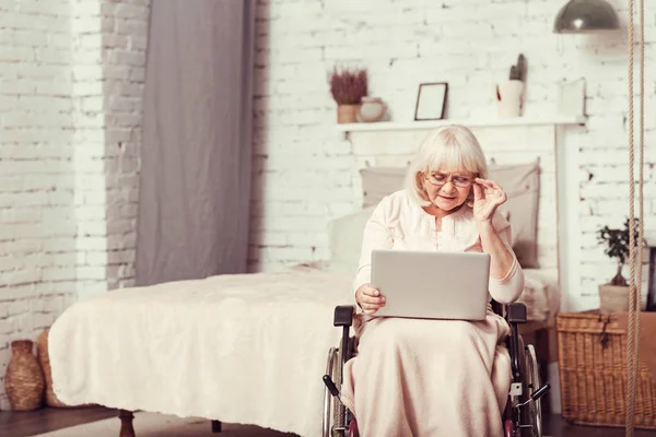 家でノート パソコンを使用してスマート ハンディキャップ引退した女性 — ストック写真
