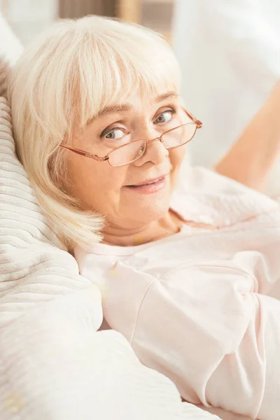 自宅のベッドで横になっている魅力的な高齢女性 — ストック写真