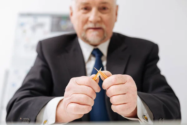 Angry powerful businessman breaking pencil in the office — Stock Photo, Image