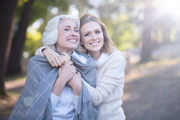 woman covering aged parent with blanket 