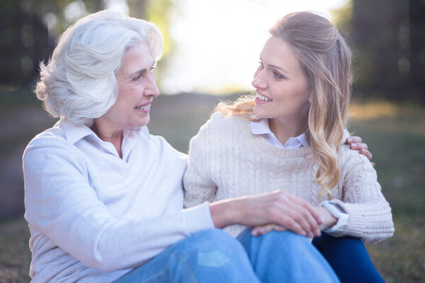 woman enjoying conversation with mother in park